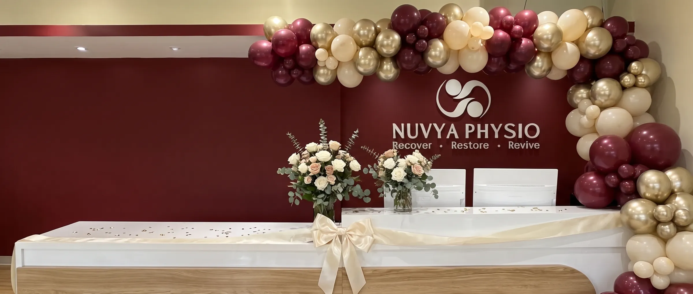 Nuvya Physio reception decorated with burgundy and gold balloons for the Grand Opening
