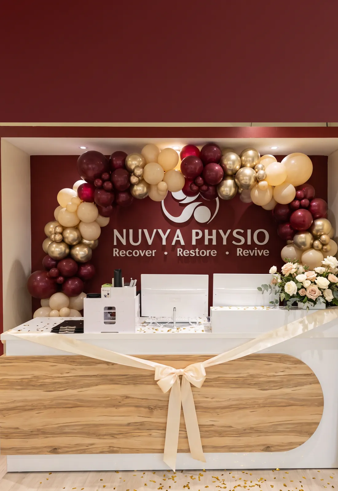 Nuvya Physio reception decorated with burgundy and gold balloons for the Grand Opening